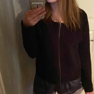 Svart mönstrad jacka från KappAhl - Säljer en svart jacka från KappAhl med geometriskt mönster och dragkedja framtill. Jackan har lång ärm och är tillverkad i ett mjukt, strukturerat material. Perfekt för dig som vill ha en stilren men ändå unik look.