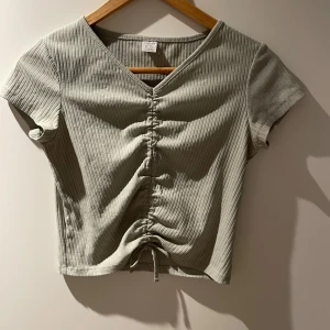 Ljusgrön ribbad topp från Lindex - Säljer en ljusgrön ribbad topp från Lindex med v-ringning och kort ärm. 