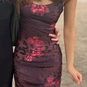 Mörkblommig långklänning med slits - Kan vara smått ”genomskinlig” i vissa ljus. Vet ej storlek men passar som XS/S, stretchig material och jag är 168cm. 