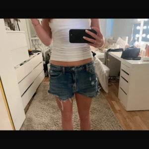Blå jeansshorts med fransar - ( Bilderna är från min Vinted !!) Säljer ett par blå jeansshorts med råa fransar nertill och slitna detaljer. Shortsen har klassisk femficksdesign och låg midja. Perfekta för sommaren och ger en avslappnad vibe.  Det finns ingen lapp eller märke då jag köpte på marknad utomlands, skulle säga storlek S !!💕💕