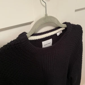 Mörk mörk blå stickad tröja från Jack & Jones - Säljer en snygg mörkblå stickad tröja från Jack & Jones. Tröjan har en klassisk rund halsringning och är perfekt för alla tillfällen. Den är i storlek S och har en stilren design som passar till det mesta. Perfekt för dig som gillar en enkel och stilren look. Helt ny!