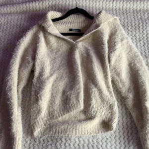 Beige fluffig stickad tröja med krage - Mysig beige stickad tröja från gina med fluffig textur och långa ärmar med en krage som snygg detalj