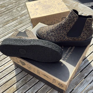 Leopardmönstrade chelsea boots från Sneaky Steve - Säljer ett par snygga chelsea boots från Sneaky Steve i leopardmönstrad mocka. Skorna har elastiska paneler på sidorna och är fodrade på insidan. Perfekta för dig som vill sticka ut med din stil.