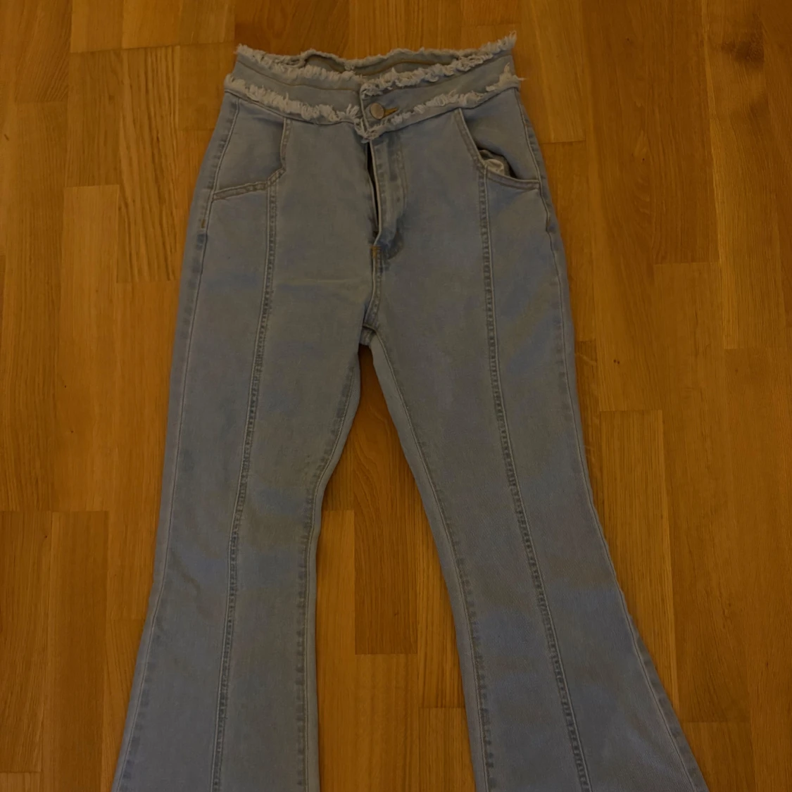 Ljusblå bootcut jeans med råa kanter