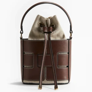 Brun och beige bucket bag med snörning - Slutsålda väskan från hm, endast använd 3 gånger och är därmed som ny.