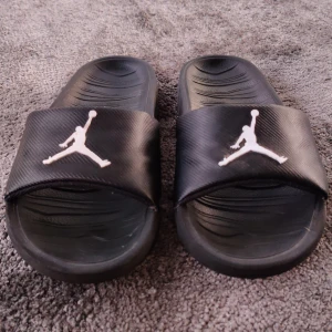 Svarta Jordan tofflor/sandaler  - Svarta Jordan tofflor som är väldigt sköna och är snygga. Dom är använda ett fåtal gånger och det går att använda dom ute och inne. Säljer dom för dom är för små.