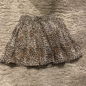 Leopardmönstrad kjol från Zara - Säljer en snygg leopardmönstrad kjol från Zara med resår i midjan. Kjolen har volanger och är i en luftig modell som passar perfekt för dig som gillar djurmönster. Färgerna går i beige, svart och brunt. Den har shorts under!❤️🌸