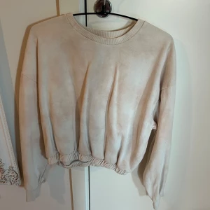 Ljusrosa/vit croppad sweatshirt från lager 157 - Säljer en ljusrosa/vit croppad sweatshirt från lager 157 med rund halsringning och resår i midjan. Tröjan har långa ärmar och är perfekt för en avslappnad stil. Superenkel att matcha med jeans eller mjukisbyxor.