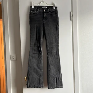 Svarta lågmidjade bootcut jeans  - Snygga svarta jeans som är lågmidjade med bootcut. Jeansen har en mörk tvätt och är tillverkade i ett mjukt denimtyg som sitter skönt på kroppen. Är i storlek petite. Kontakta mig vid frågor eller funderingar😊                                                            Midjemått rakt över: 34cm                                                Innerbenslängd: 76cm
