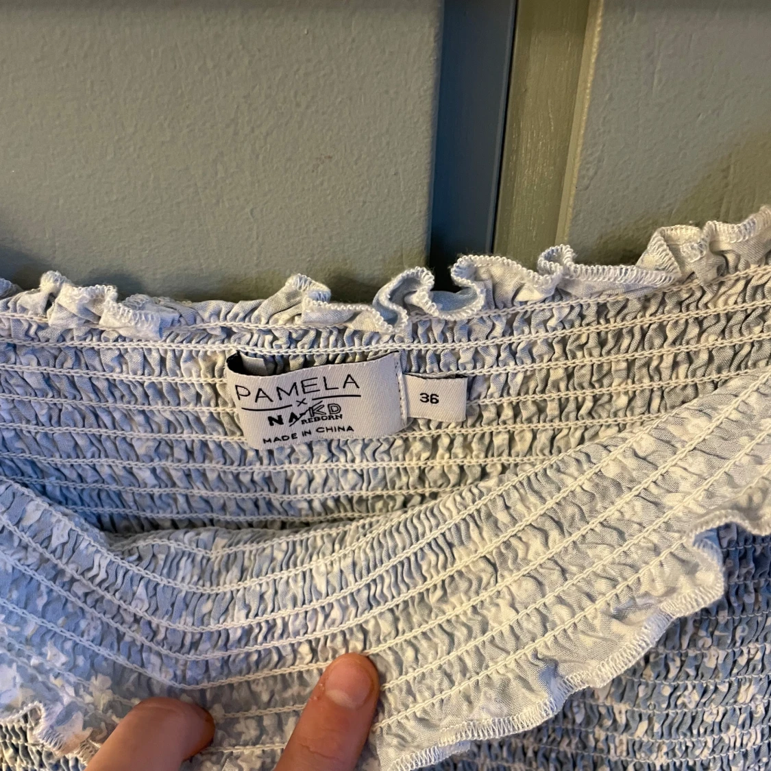 Ljusblå croppad blus med blommigt mönster från NA-KD - 1