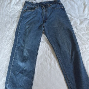 Levi's 501 blå jeans - Klassiska blå Levi's 501 jeans och fiten är stay loose. Perfekta för dig som gillar mer baggy jeans och vill ha ett par ikoniska jeans i garderoben.