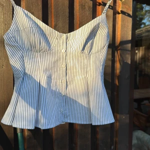 Randig croppad linnetopp från Zara - Säljer en vit och blå randigt linne från Zara som är väldigt eftertraktat. Perfekta för en sommar dag💕