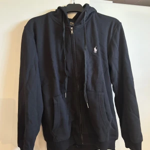 Svart hoodie från Polo Ralph Lauren - Säljer en svart polo Ralph lauren i storlek M. Kan även passa S då den blivit lite mindre i tvätt.