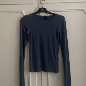 tajt blå långärmad tröja från Gina Tricot - Säljer en tajt mörkblå långärmad tröja från Gina Tricot i storlek XS. Tröjan har en rund halsringning med lätt utsvängda armar. Tröjan har inga defekter alls och är i nyskick. Skriv för frågor💗