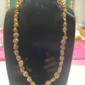 Halsband med oregelbundna pärlor - Snyggt handgjort halsband med oregelbundna, äkta sötvatten pärlor i naturfärg. Pärlorna har en skimrande yta och sitter på rad längs hela halsbandet. Perfekt för dig som gillar unika smycken med naturlig känsla.
