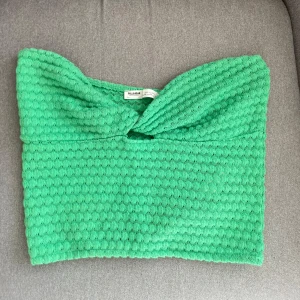 Grön bandeau topp från Pull&Bear - Säljer en grön bandeau topp från Pull&Bear med en twistad detalj framtill. Superfin, somrig färg🤩
