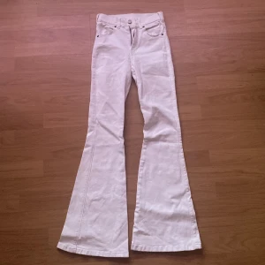 Vita bootcut jeans från Dr Denim - Säljer ett par vita bootcut jeans från Dr Denim, modell Macy. Byxorna har hög midja, klassisk femficksdesign och stängs med dragkedja och knapp. Perfekta för dig som gillar en retroinspirerad look.