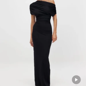 Svart offshoulder långklänning - Supersnygg svart långklänning med offshoulder och draperad överdel. Klänningen har markerad midja. Materialet är mjukt. Den ska sitta tajtare men den var för stor på mig. Köpt på NA-KD och använd endast 1 gång