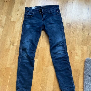 Mörkblå jeans från Replay - Snygga mörkblå jeans från Replay, modell Anbass. De har en slim passform och klassisk femficksdesign. Perfekta för en stilren look med dragkedja och knapp framtill. Nypris ca 1700. Längd 32
