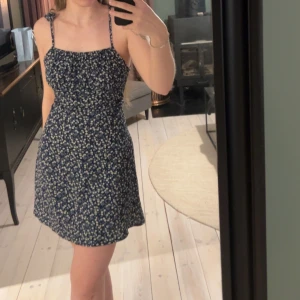 Klänning  - I fint skick. Inte använd många gånger. Dragkedja baktill och justerbara axelband med knytning 