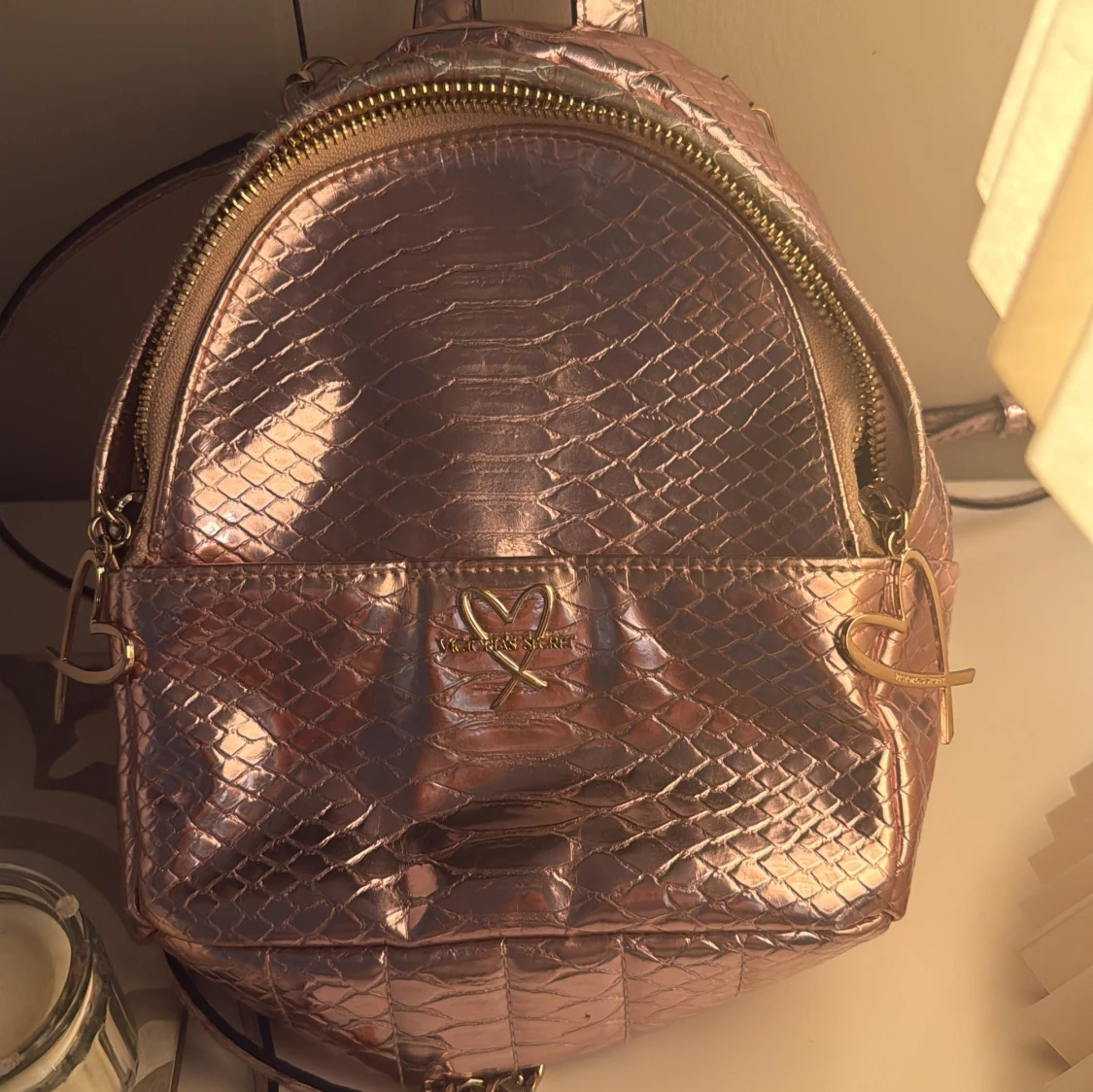 Rosa ryggsäck med ormskinnsmönster