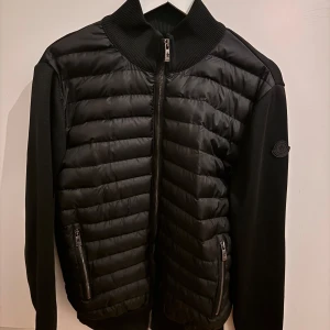 Cardigan från Moncler, Black Label - Snygg svart jacka från moncler. Jackan är så gott som nu och endast använd väldigt fåtal gånger! Jackan är i Stlk 3, jag skulle säga medium.
