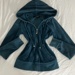  Juicy Couture - Snygg blå sipup från Juicy Couture. Perfekt för en avslappnad stil. Jackan har långa ärmar och en glittrig dragkedja som ger en extra touch.