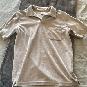 Beige kortärmad piké från S.C.W - Säljer en stilren beige piké från S.C.W med en klassisk krage och bröstficka. Perfekt för en avslappnad look. Tillverkad i ett mjukt material som känns skönt mot huden.