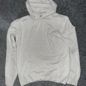 Grå/beige kashmir hoodie från Oscar Jacobson - Säljer en stilren grå hoodie från Oscar Jacobson. Den är i mycket bra skick endast använd några gånger. Den är tillverkad i kashmir och ullblandning och har en klassisk design med huva och långa ärmar. Nypris 1600kr! Skriv för frågor 🪐🪐