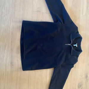 Marinblå tröja med dragkedja från H&M - Säljer en stilren marinblå tröja från H&M med dragkedja vid halsen. Tröjan har en normal passform och är oanvänd. Passar bra till både jeans och chinos. Nypris: 350kr