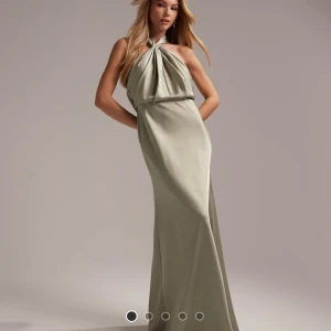 Ljus grön långklänning med halterneck - Elegant ljus grön/beige långklänning med halterneck-design och draperad framsida. Lång i modellen och faller väldigt fint😊