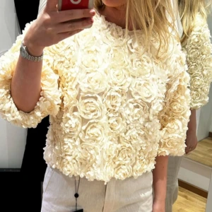 Beige blommig tröja - Säljer en unik beige tröja med blommigt mönster i 3D-effekt. Tröjan har en normal passform och trekvartsärmar, perfekt för att sticka ut i mängden. Passar bra till både jeans och kjol. 🌸