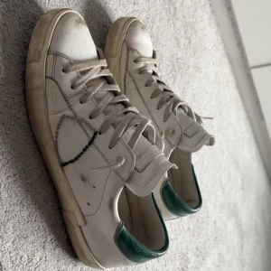 Vita sneakers från Philippe Model - Snygga vita sneakers från Philippe Model med gröna detaljer. Skorna har snörning och en klassisk rund tå.  Bra men använd skick, 1350kr  priset kan diskuteras vid snabb affär, box och allt sånt där tillkommer, storlek 40, hör av er😁😁