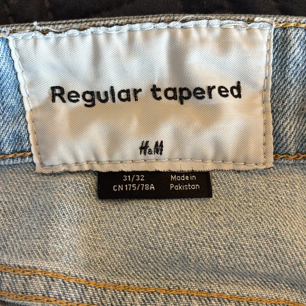 Säljer ett par ljusblå jeans från H&M med en regular tapered passform. De har en klassisk femficksdesign och är tillverkade i ett bekvämt denimtyg. Perfekta för sommaren! . Farkut & Housut.