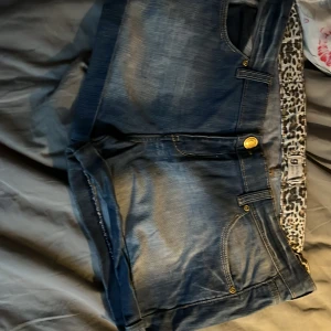 Blå jeansshorts från Perfect Jeans - Snygga blå jeansshorts från Perfect Jeans med leopardmönstrad insida. De har en klassisk femficksdesign och knäppning fram. Perfekta för en avslappnad sommarlook!