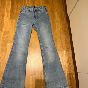 Blå bootcut jeans - Snygga blå bootcut jeans med klassisk femficksdesign. De har en lätt tvättad look och är perfekta för en avslappnad stil. Passar bra till både sneakers och klackar.