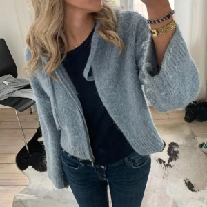 Stickad tröja med dragkedja - Blå stickad tröja med dragkedja och luva från Zara! Fint skick, använt några gånger bara💗Själva materialet är ”fluffigt” så det är inte som det är nopprigt utan köpte den så!!  Storlek M-L, men själva modellen är kort. 