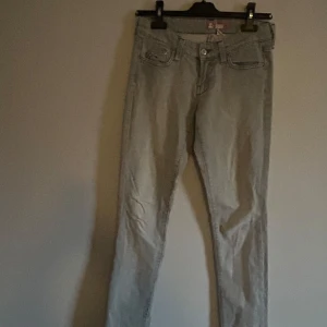 Grå jeans från SQIN - Snygga grå jeans från SQIN med en klassisk femficksdesign. De har en knapp och dragkedja framtill och är perfekta för en stilren look. Passar bra till både vardag och mer uppklädda tillfällen.