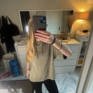 Beige hoodie med korta ärmar - Säljer en beige hoodie med korta ärmar och justerbar dragsko i halsen. Perfekt för en avslappnad stil. Passar bra till jeans eller leggings.