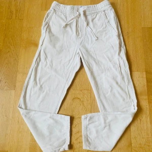 Beige linnebyxor från Zara - Säljer ett par bekväma beige linnebyxor från Zara med elastisk midja och snörning. Perfekta för en avslappnad stil. Byxorna har sidfickor och är tillverkade i ett mjukt material.
