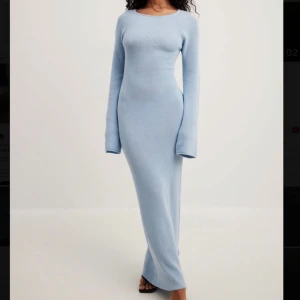 Ljusblå maxiklänning med öppen rygg - Säljer en ljusblå ribbad långklänning med långärmad design. Klänningen har en öppen rygg med snörning. Använd en gång förra sommaren. Super fin och bekväm!