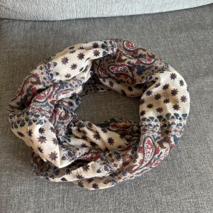 Flerfärgad tub sjal i nyskick - •Sjal med ett vackert mönster i olika färger.  •Den har ett paisley-liknande tryck kombinerat med små stjärnor, vilket ger den ett unikt utseende. •Använd 1-2 gånger, som ny. •80 % viskos, 20 % bomull •Djurfritt och rökfritt hem.