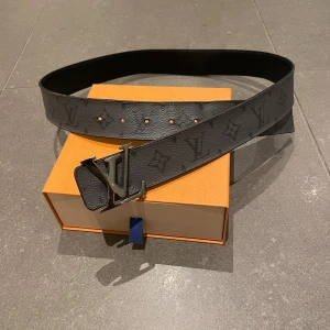 Svart bälte från Louis Vuitton - Säljer ett Äkta Louis vitton bälte, dubbel vikt så man kan byta till helsvart eller den klassiska som visas på bilden, man får med box till. Skriv om ni har några frågor 