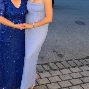 Ljusblå glittrig långklänning - Snygg ljusblå långklänning med glittrande detaljer. Klänningen har smala axelband och en öppen rygg. Den är från oh polly och endast använd en gång💙