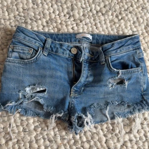Blå Lågmidjade jeansshorts med slitningar - Säljer ett par Lågmidjade jeansshorts ifrån Gina tricot (säljs ej längre) i storlek 146 men passade mig tills jag blev ungefär 155, skulle säga att de passar folk som är xxs 