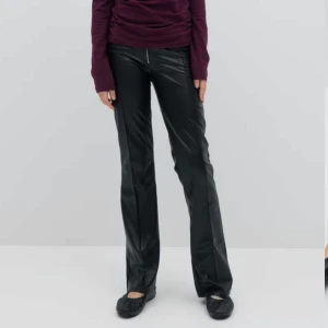 Svarta skinnbyxor med dragkedja - Snygga svarta skinnbyxor med en framträdande dragkedja framtill. Byxorna har en tight passform och är högmidjade, vilket ger en stilren och modern look. Perfekta för en trendig outfit.