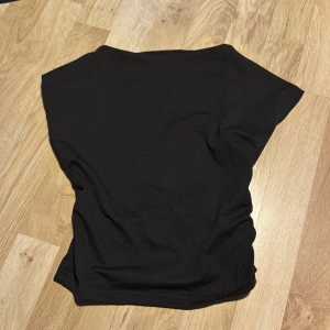 Svart topp från Shein - Säljer en stilren svart, backless topp från Shein. Toppen har en enkel design med korta ärmar och är perfekt för en minimalistisk look. Passar bra till både jeans och kjol