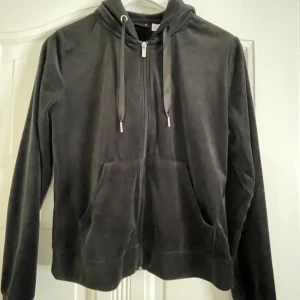 Svart hoodie från Gina Tricot - Säljer en svart hoodie från Gina Tricot i mjukt material. Den har dragkedja framtill och en praktisk huva med snören. 