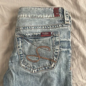 Blå jeans från Silver - Snygga blå jeans från Silver med en klassisk femficksdesign och broderad bakficka. Jeansen har en bootcut-stil och är tillverkade i denim. Innerbenslängd: 73 cm och midjemått: 39 cm.❤️tecken på användning finns. 