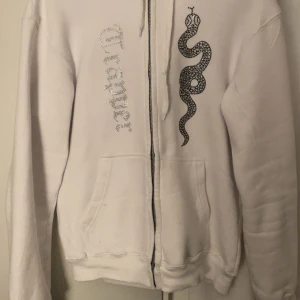 madebytrappers rhinesthone hoodie  - Rhinestonehoodie från madebytrappers i väldigt bra skick! Storlek L. Ända dåliga är att ena snöret remsat upp litegrann (se bild).